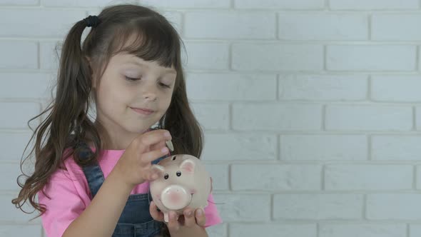 Child put coin in a piggy bank.