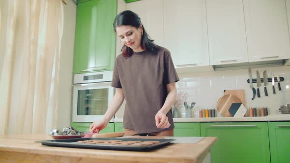 Young Caucasian Woman Cuts Out Cookies From a Dough at Home Kitchen