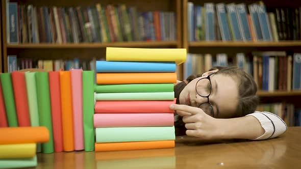 Girl Schoolgirl Counts the Number of Books in the Library