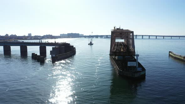 An low angle shot of a swing bridge opening on a bay in Queens, NY. The camera trucks right as a dre