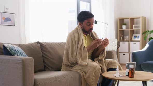 Sick Man Measuring Temperature By Thermometer