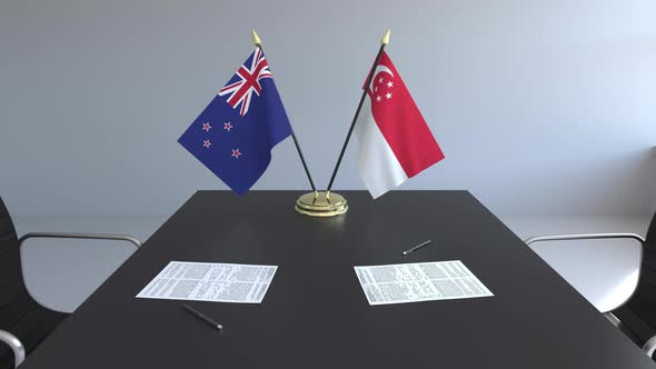 Flags of New Zealand and Singapore on the Table