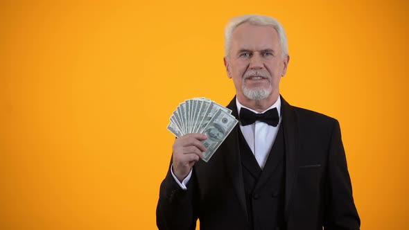 Happy Old Man in Suit Holding Dollars and Showing Thumbs-Up, Business Income
