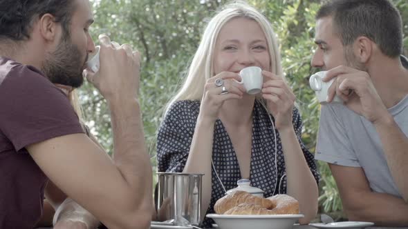 Group of Four Happy Men and Women Friends Smile Laugh and Drink Coffee During Italian Breakfast in