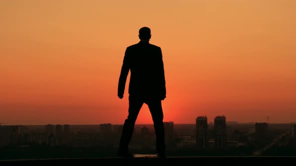 Successful Businessman Looking at the Town at the Dawn