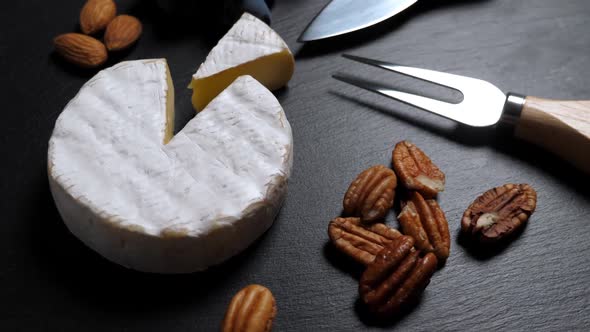 Sliced Cheese, Nuts, Grape, Honey and Knife on Shale Platter