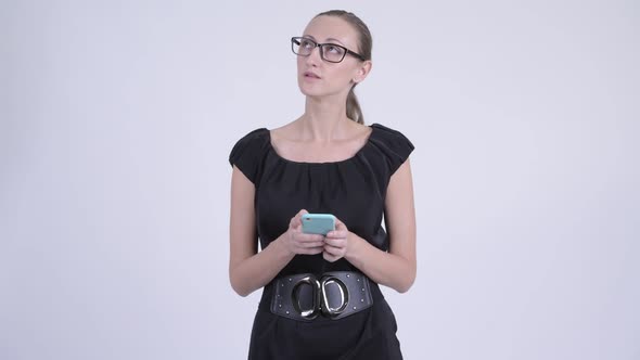 Happy Blonde Businesswoman Thinking While Using Phone