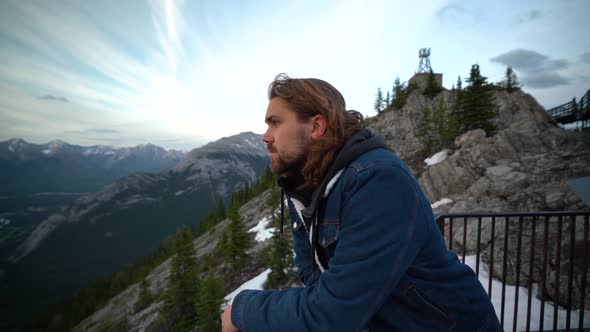 Smiling young man looking out over Jasper National, Alberta, Canada