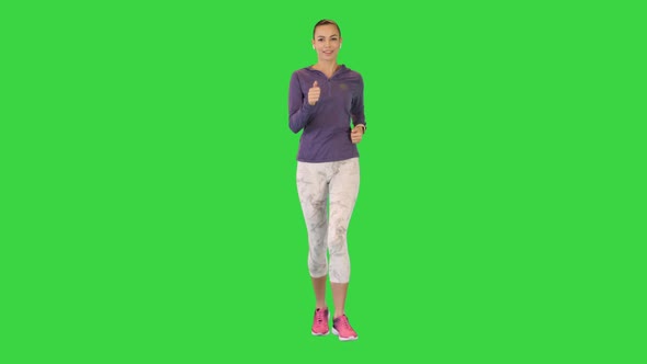 Female Runner Athlete Running and Listening Music in Wireless Ear Buds on a Green Screen Chroma Key