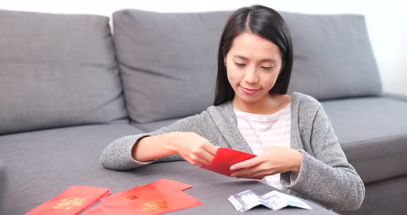 Woman putting banknote into red packet