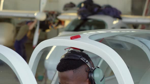 Black Pilot Using Headset in Cockpit