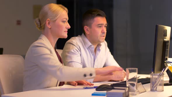 Business Team with Computer Working Late at Office 