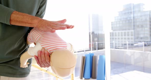 Male paramedic rubbing dummy back while training