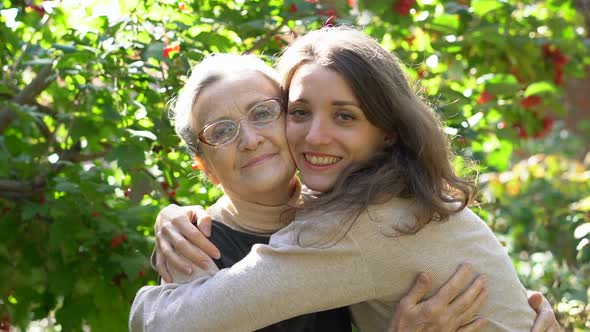 Happy Senior Mother in Eyeglasses is Hugging Her Adult Daughter the Women are Enjoying Together