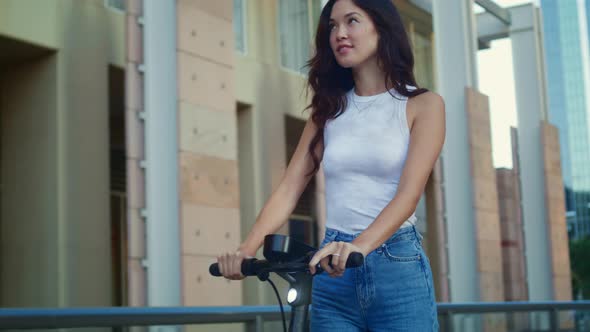 Carefree Woman Riding Scooter on Weekend