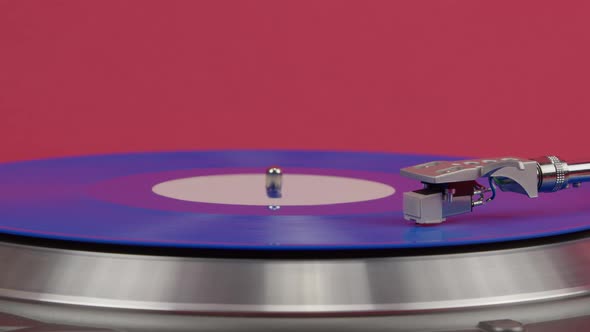 Blue Vinyl Record Spinning on Turntable Isolated on Red