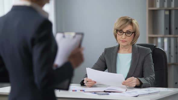 Strict Serious Lady Boss Looking Contemptuously at Secretary, Poor Performance