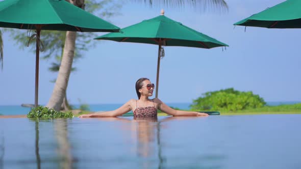 Young asian woman enjoy around outdoor swimming pool for leisure