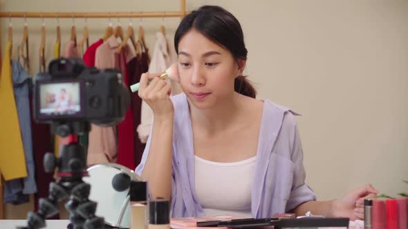 Beauty blogger present beauty cosmetics sitting in front camera for recording video Asian woman.