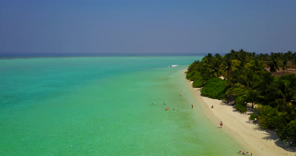 Wide drone copy space shot of a summer white paradise sand beach and blue water background in colour