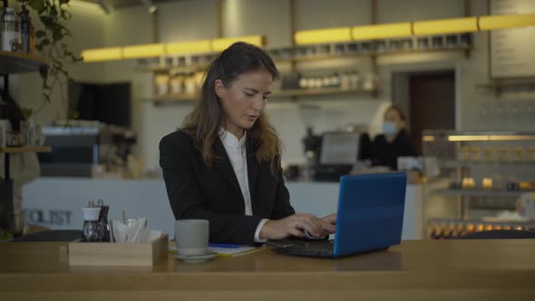 Confident Businesswoman Typing on Laptop Keyboard and Smiling at Camera. Portrait of Positive Young