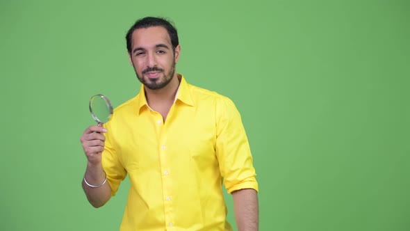 Young Bearded Indian Businessman Playing with Magnifying Glass