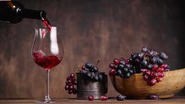 Unrecognizable Person Filling Wineglass Near Grapes