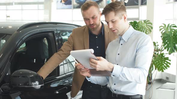 Affable Handsome Consultant and Client in Dealership