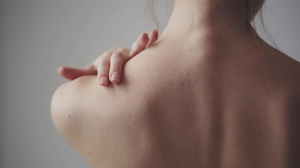 Naked Woman Touches Her Neck and Shoulders