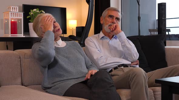 An Elderly Couple Sits on A Couch in An Apartment and Argues