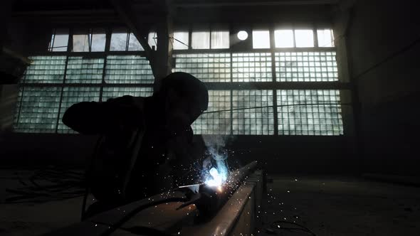 Close Up of Factory Worker Welds Metal Using a Welding Machine