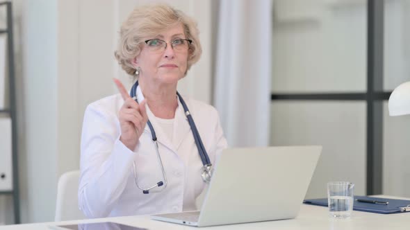 Old Female Doctor with Laptop Showing No Sign By Finger