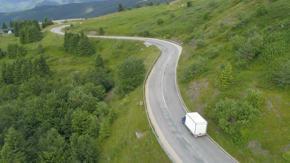 White Delivery Truck or Van Driving Down the Mountain Road. Logistic Transport Semi Truck Lorry