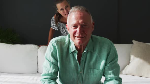 Portrait of happy caucasian senior couple smiling and talking while having a video call at home