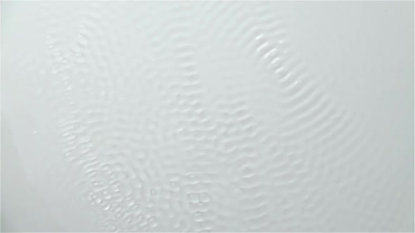 Reflection of the Water Creates Waves Caused By Vibration. White Background. Slow Motion