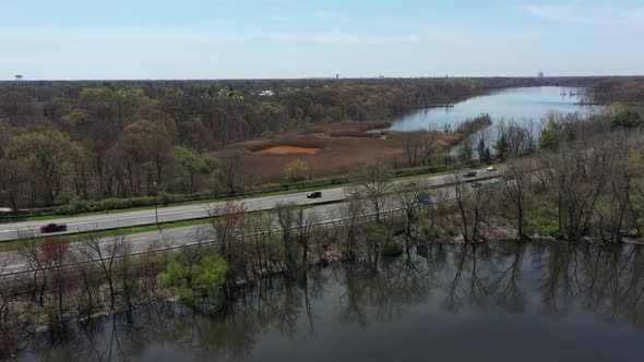 An aerial view of reflective lakes during the day. The drone camera tilts down while panning left ov