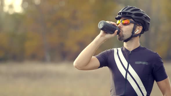 Cyclist Fitness Riding On Road Bike And Drinking Water. Triathlon Cycling Workout.Triathlete Bicycle