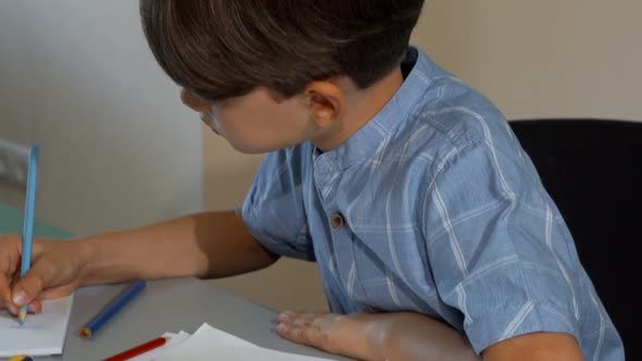 Cute Little Boy Smiling To the Camera While Drawing