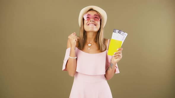 Female is Holding Passport and Tickets Smiling Saying Yes and Looking Overjoyed