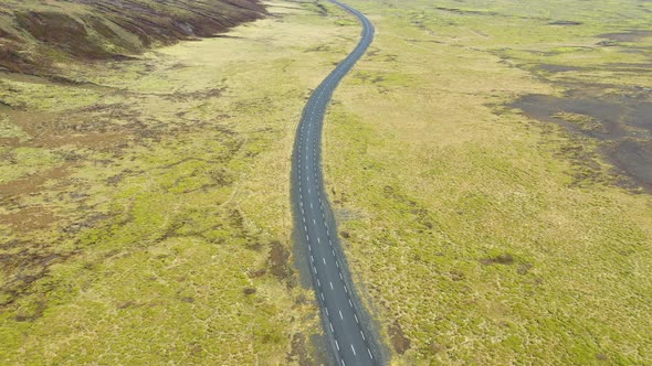 Aerial View of Asphalt Road and Huge Lava Plateau Covered with Green Moss in Iceland