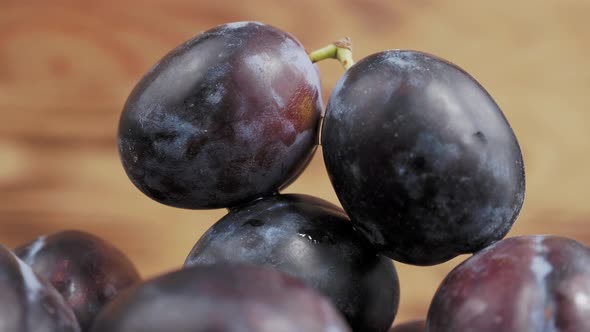 Plum on a Wooden Rotating Cup on a Wooden Background