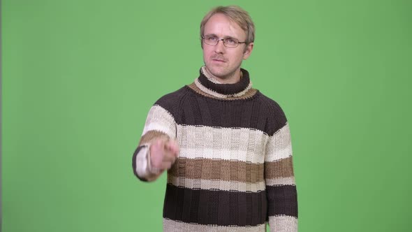 Studio Shot of Blonde Handsome Man Thinking While Pointing Finger