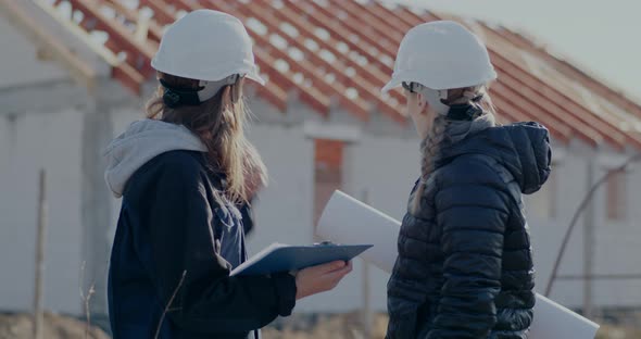 Female Contractor Discussing Over Incomplete Building with Engineer