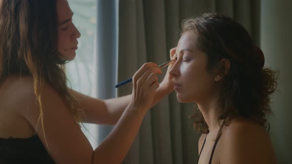 A Makeup Artist Makes a Bright Makeup for a Beautiful Girl Model