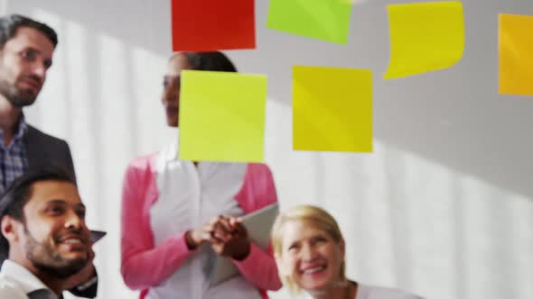 Businesspeople interacting over sticky notes