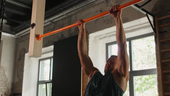 Young Man Exercising on Horizontal Bar in Gym