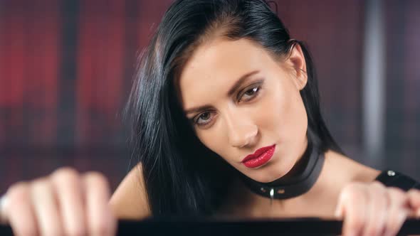 Face of Beautiful Lust Female in Latex and Leather Collar Having Debauchery Emotion
