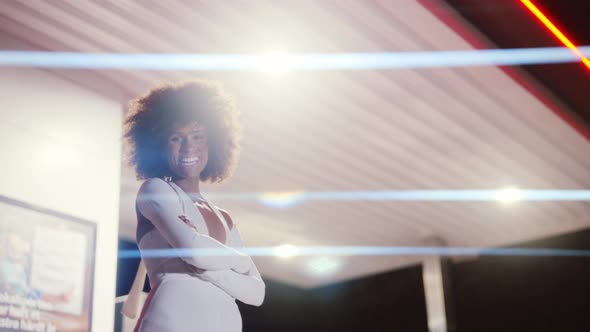 Woman With Afro In Jumpsuit Posing In Gas Station At Night