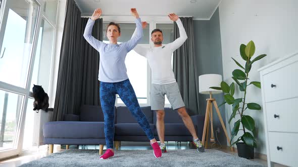 Caucasian Couple is Doing Cardio Exercise at Home in Cozy Bright Room Slow Motion