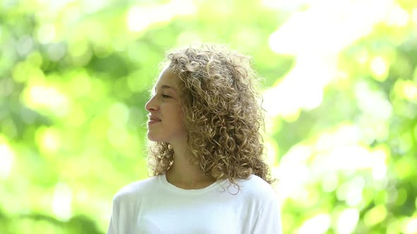 Smiling blonde girl video portrait at park